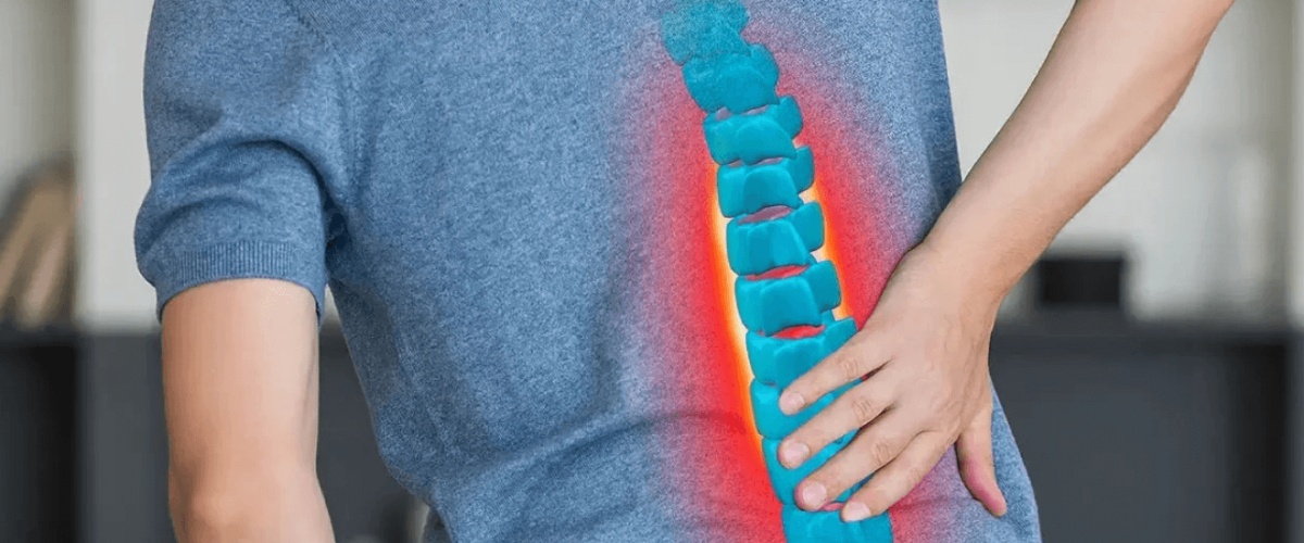 Person holding lower back in pain, highlighted spine. Relieve discomfort with Desert Spine and Sports Physicians, Arizona.