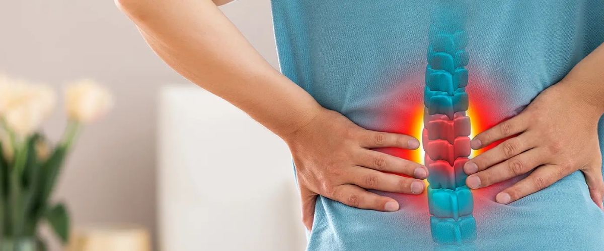 Person holds lower back with spinal pain highlighted, conveying Desert Spine and Sports Physicians' focus on spine health in Arizona.