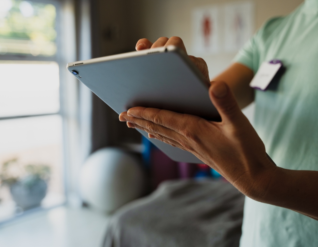 Healthcare professional using a tablet for digital patient records. Modernize workflow, enhance care, and improve accuracy.