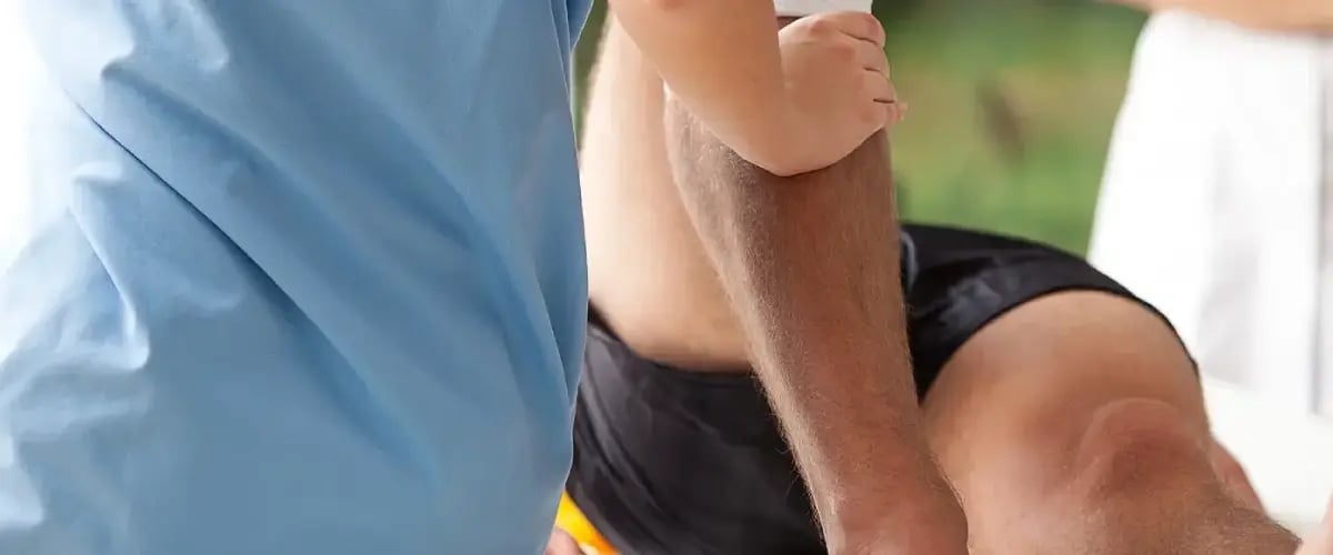 Physical therapist assisting patient with arm rehabilitation at Desert Spine and Sports Physicians, AZ.
