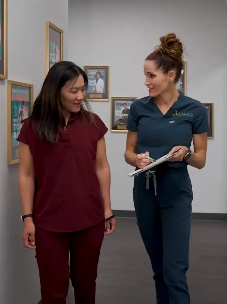 Two healthcare professionals discussing patient care at Desert Spine and Sports Physicians, Arizona.