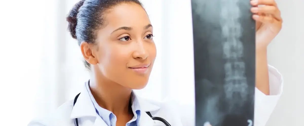 Doctor at Desert Spine and Sports Physicians reviews a spine X-ray, ensuring expert orthopedic care in Arizona.