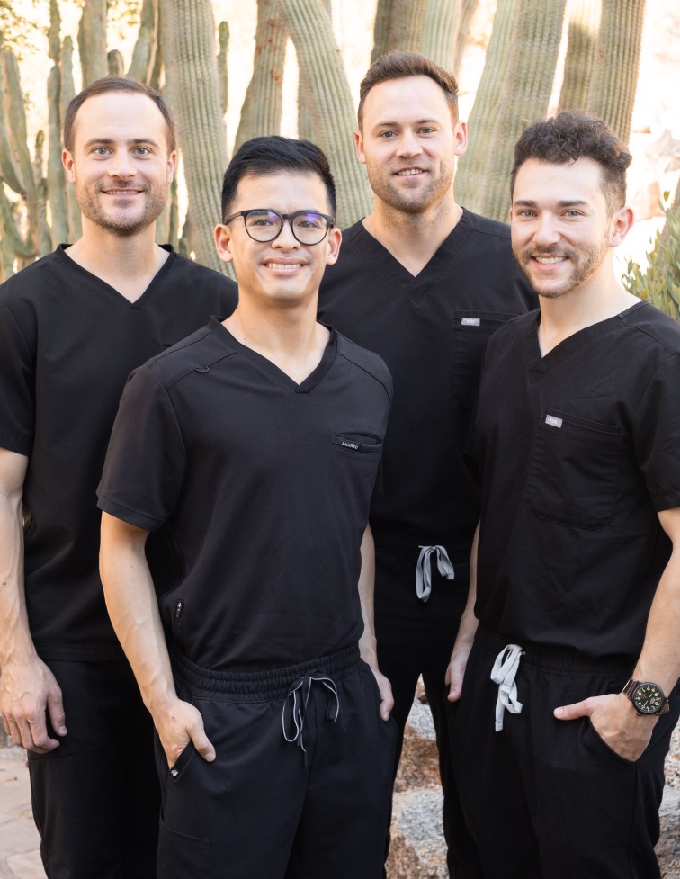 Four DSSP professionals in black scrubs, standing confidently outdoors, highlighting teamwork and expertise.