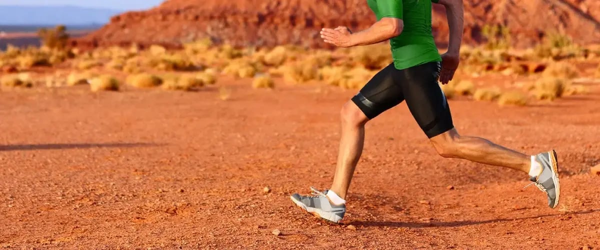 Man running across Arizona desert terrain, showcasing Desert Spine and Sports Physicians' expertise in sports medicine and rehabilitation.
