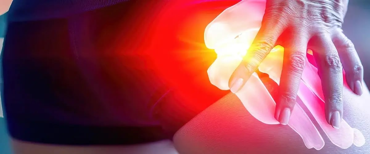 Person holding hip, highlighting pain relief. Desert Spine and Sports Physicians specializes in advanced care solutions.