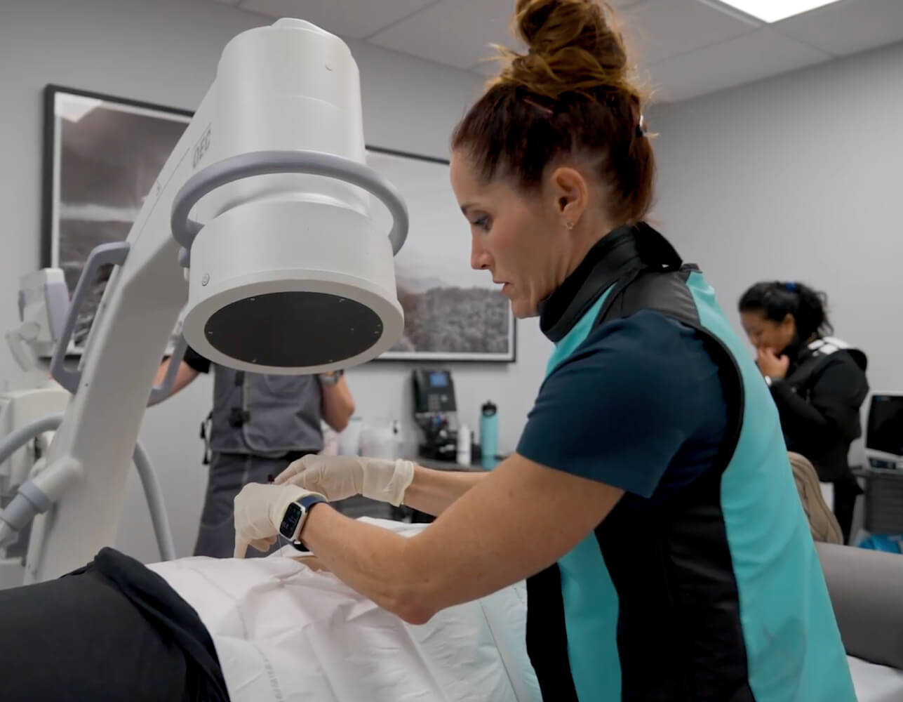 Dr. Susan Sorosky administering pain management procedure using advanced imaging technology in a clinical setting.