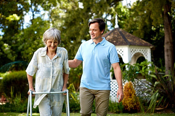 young man walking next to an elderly woman with a walker
